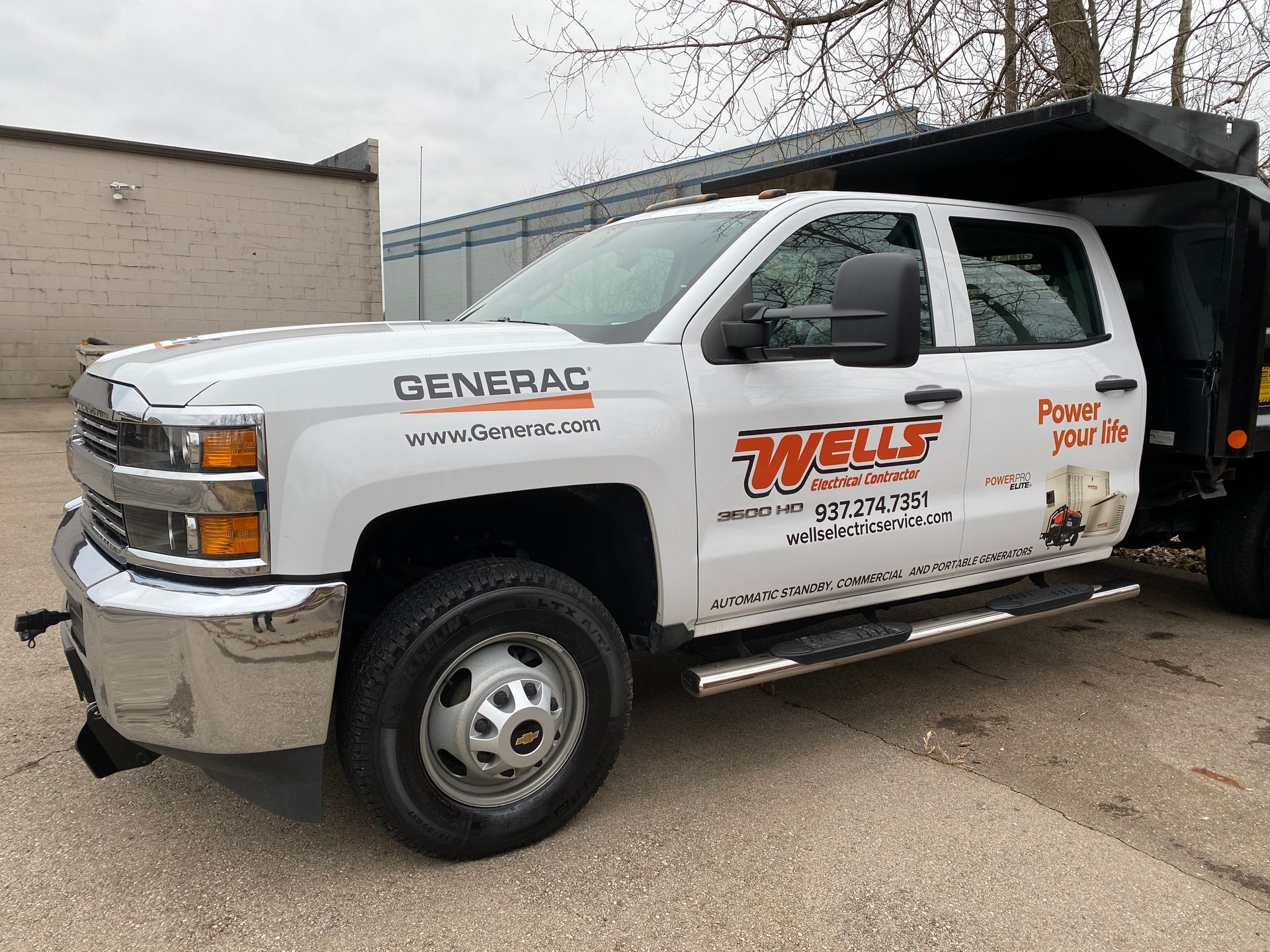 White Wells Construction dump truck parked outside.
