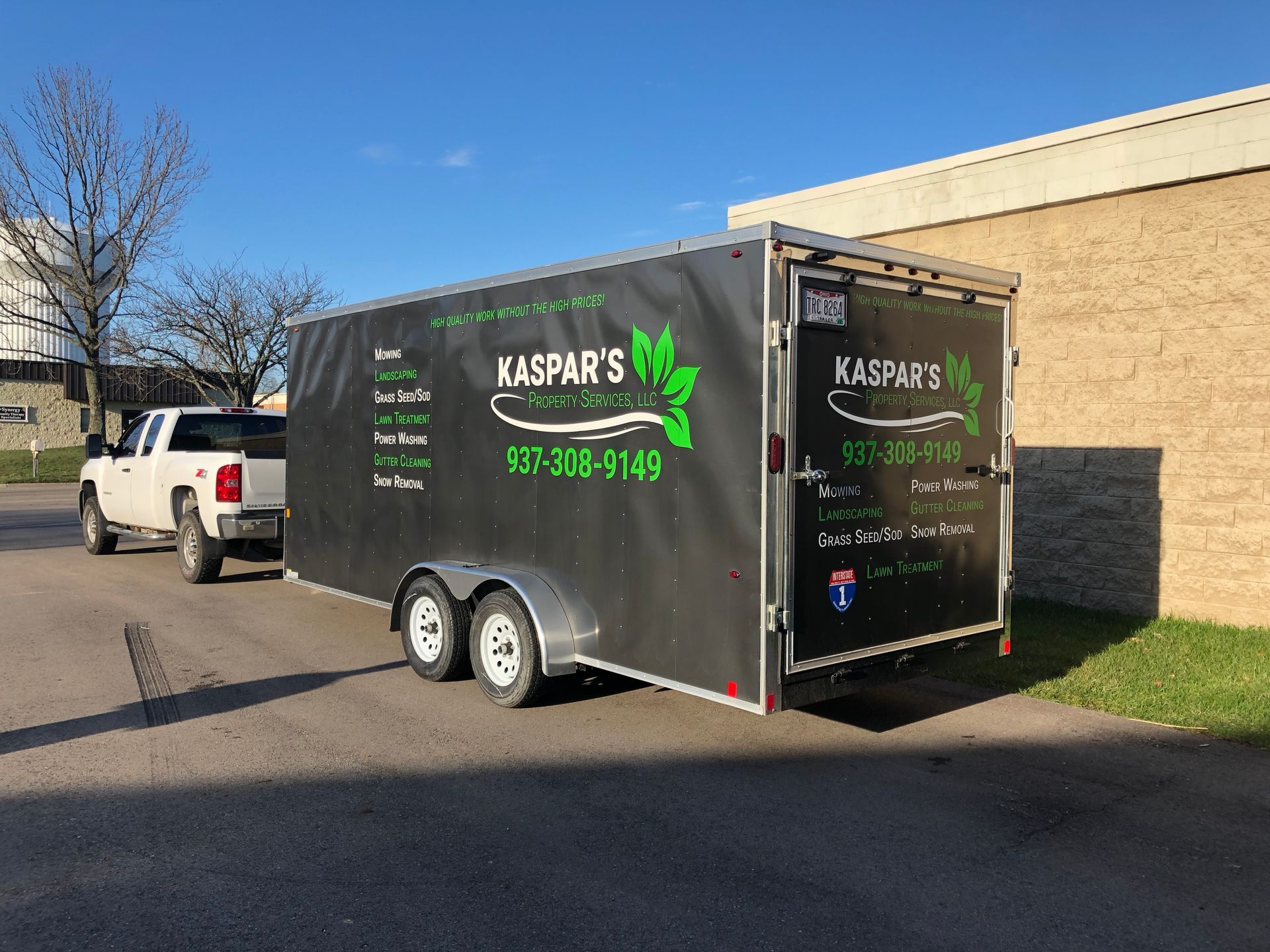 A white truck towing a black trailer with
