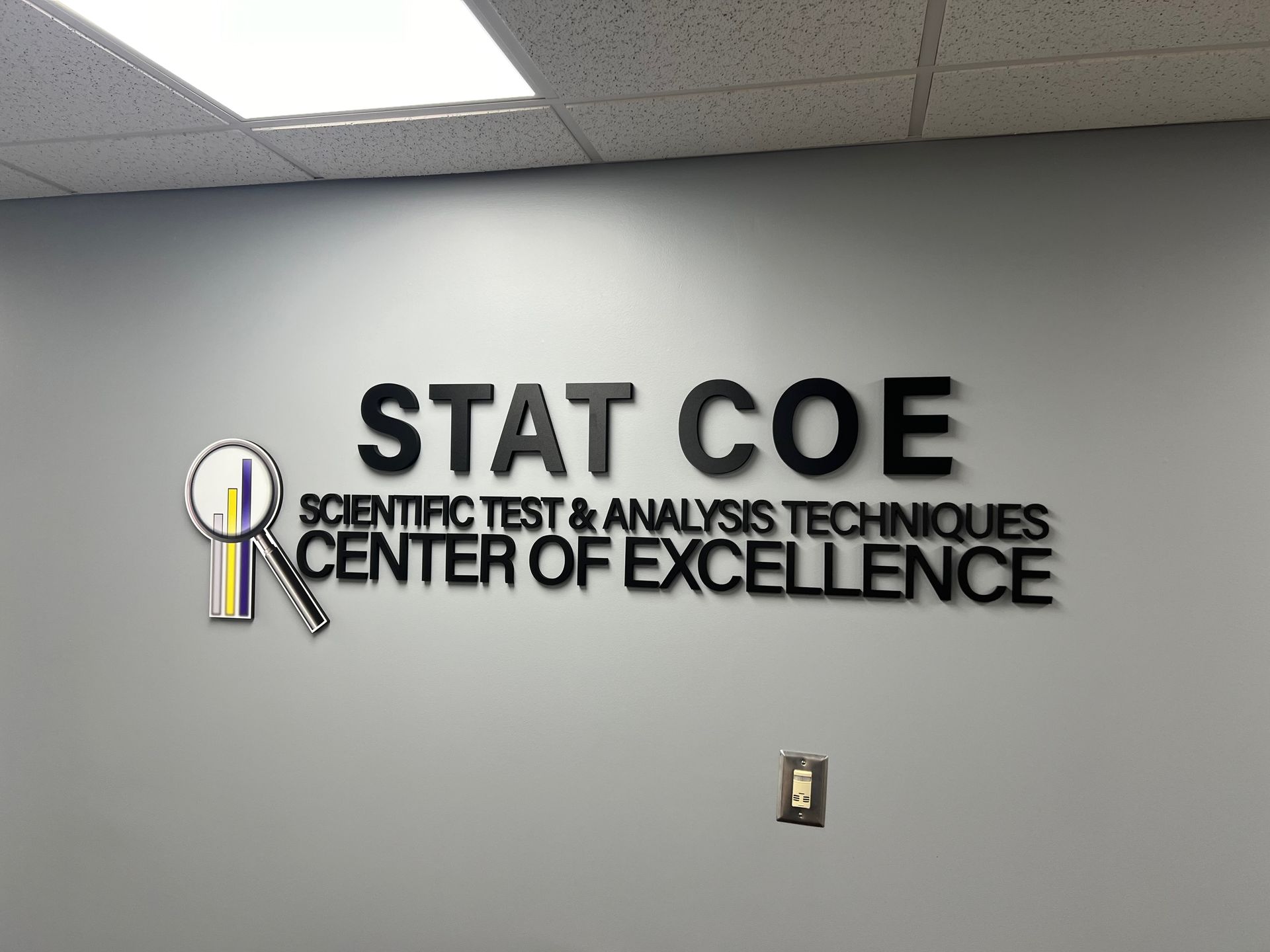 Sign on a gray wall: 