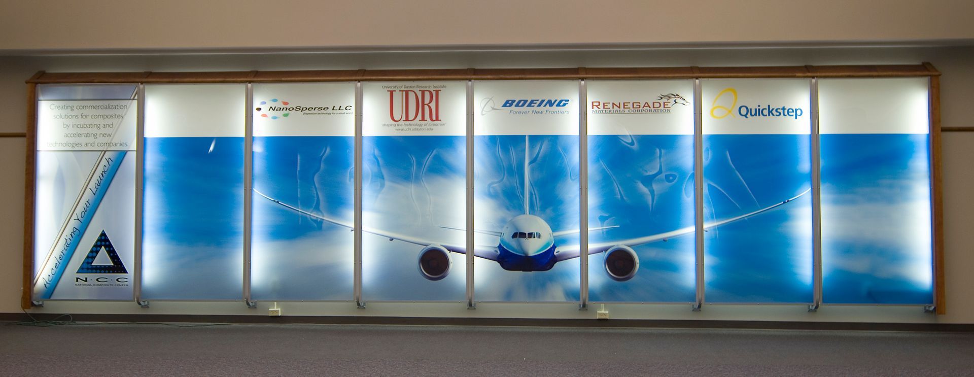 Advertising display featuring a Delta Airlines jet against a blue sky background. Logos of various companies are shown.