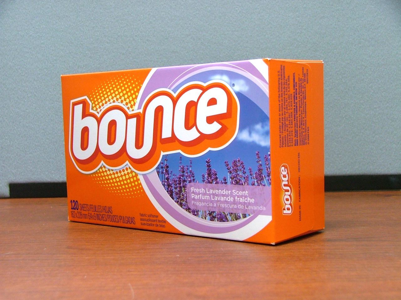 Box of Bounce dryer sheets, orange with lavender scent details, on a wooden surface.