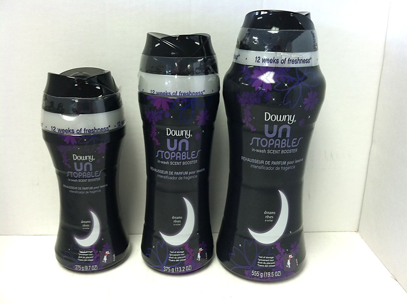 Three bottles of Downy Unstopables laundry scent booster, black with purple, white moon, and silver accents.