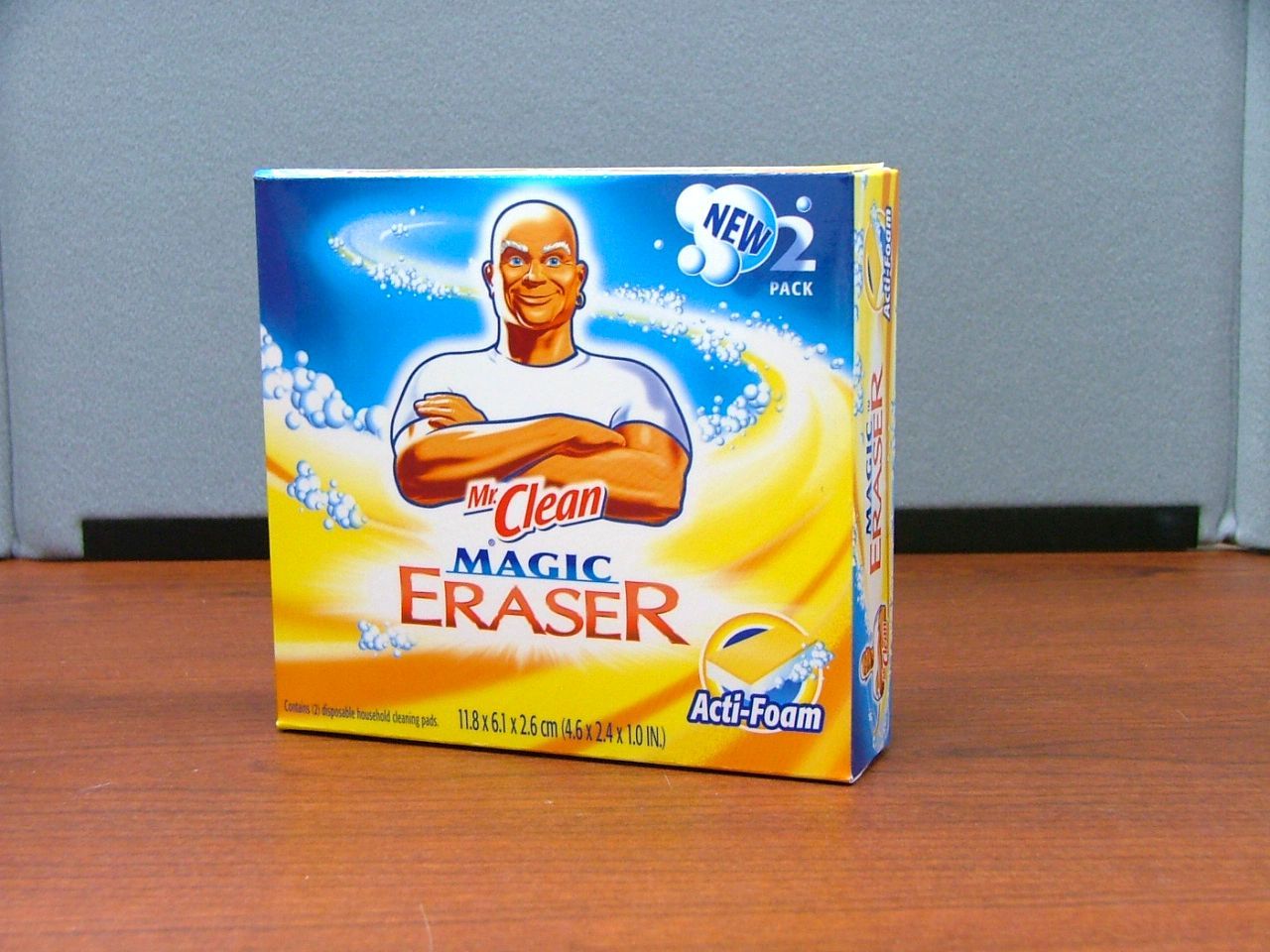 Box of Mr. Clean Magic Erasers on a wood table. Blue and yellow packaging with Mr. Clean logo.