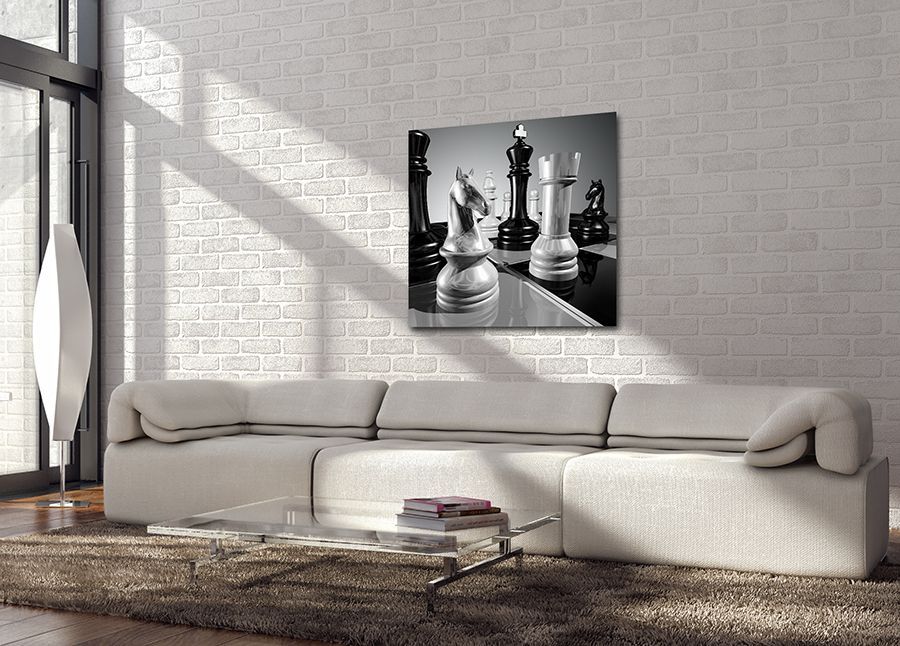 A modern living room with a sofa, glass table, and a black-and-white chess photo on the wall.