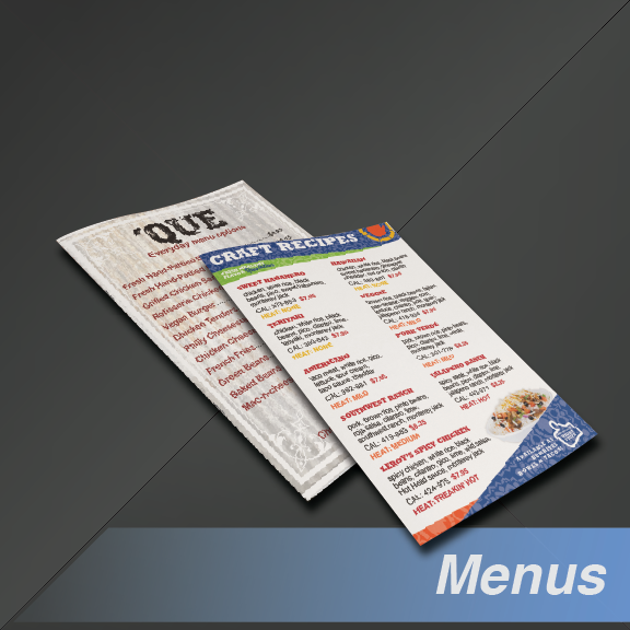 Two restaurant menus, one open, on a dark surface.