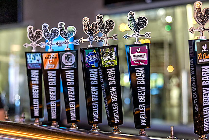 Beer taps at Mueller Brew Barn with rooster-shaped handles, close-up shot.
