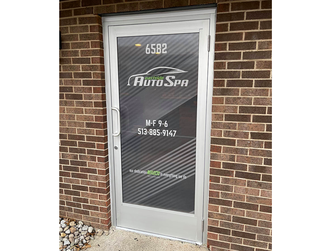 Auto Spa storefront door with logo and address on a brick building.
