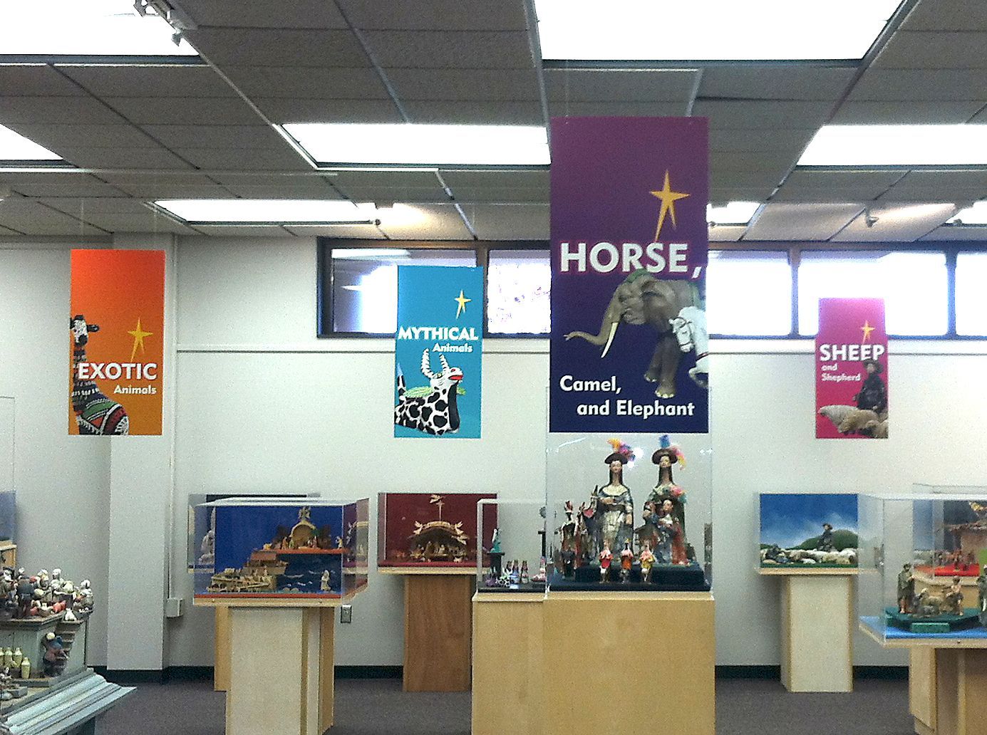 Signs for animals in a display room, including horse, camel, and elephant.