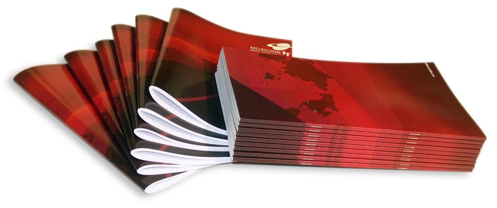 A stack of red and black brochures fanned out, displaying white pages.