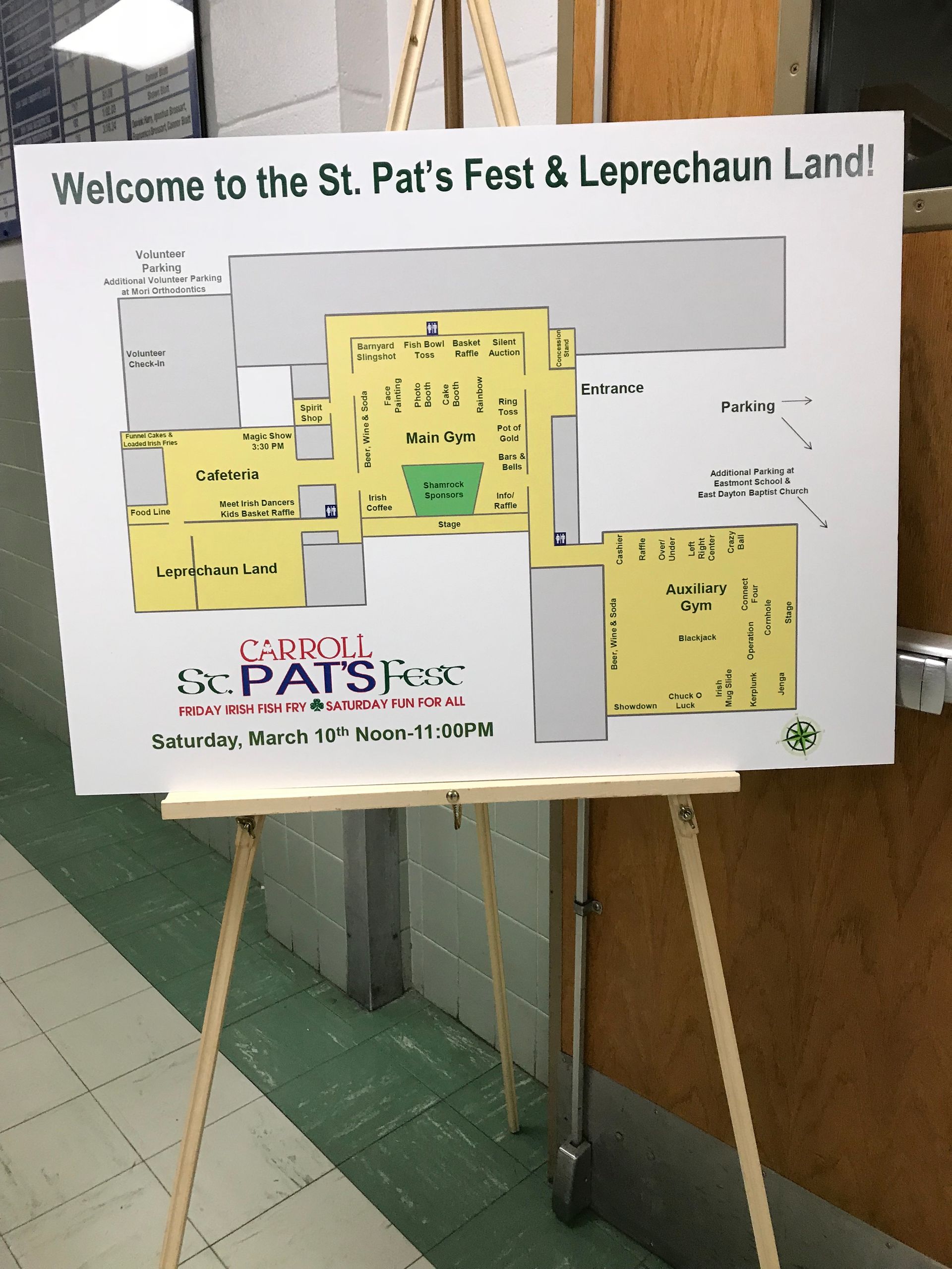 A sign on an easel welcomes to St. Pat's Fest & Leprechaun Land; map of the event in green and yellow.