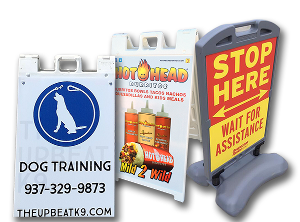 Three white plastic sandwich board signs: dog training, food promotion, and stop sign.