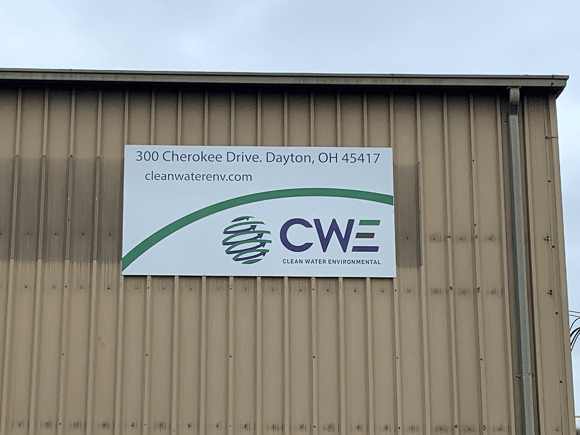 Sign for CWE (Custom Welding and Engineering) on a corrugated building, Dayton, Ohio.