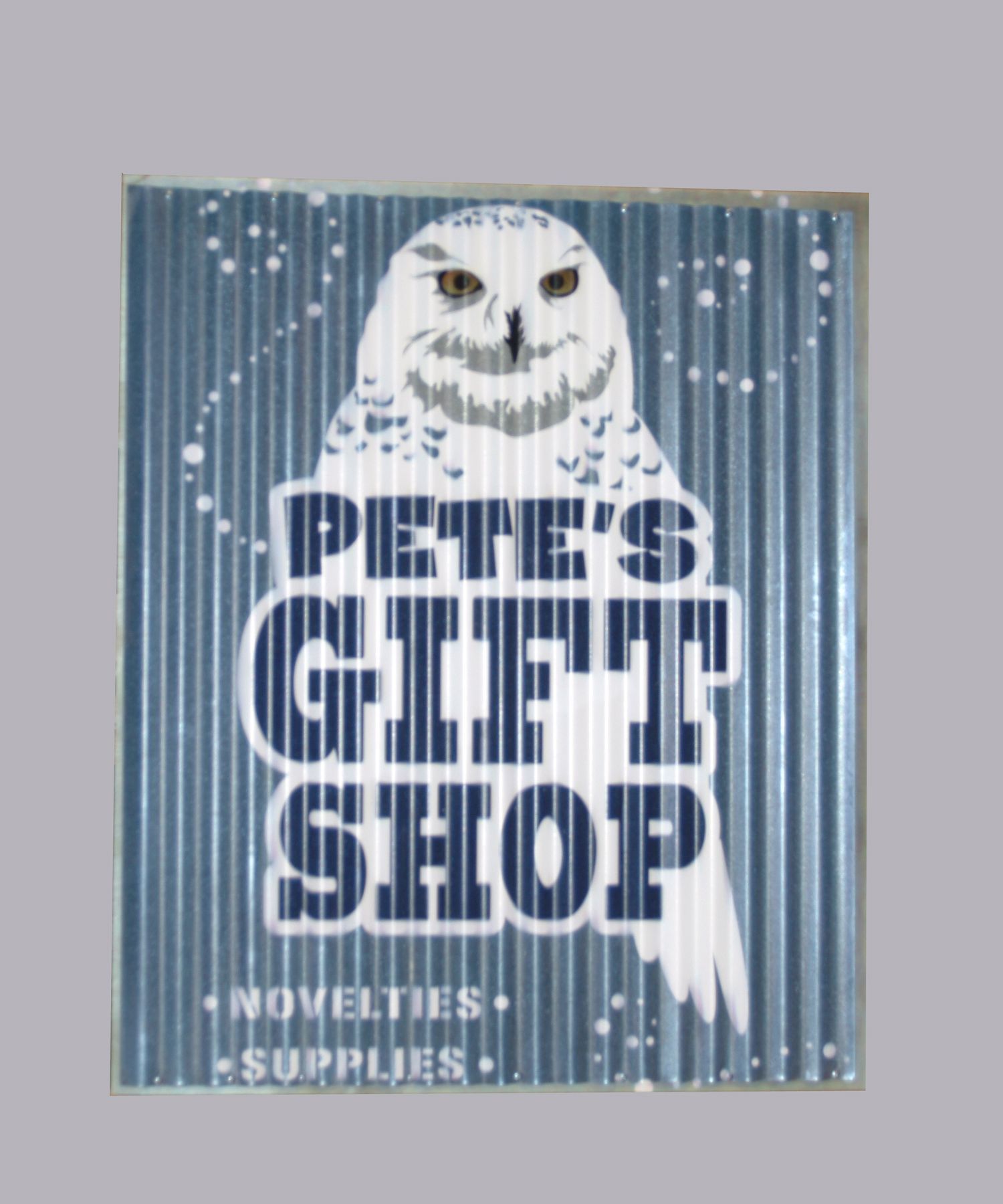 Pete's Gift Shop sign featuring a white owl and blue corrugated background with 