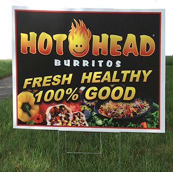Sign advertising Hot Head Burritos. Black background with logo, food images, and text: 