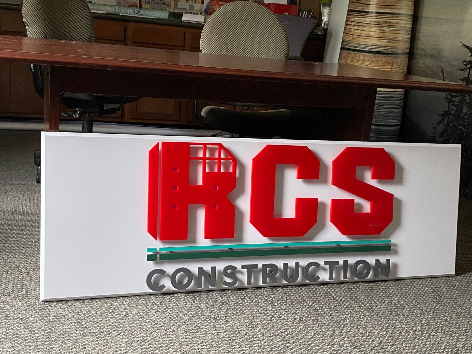 Sign for RCS Construction: red letters on a white background. 
