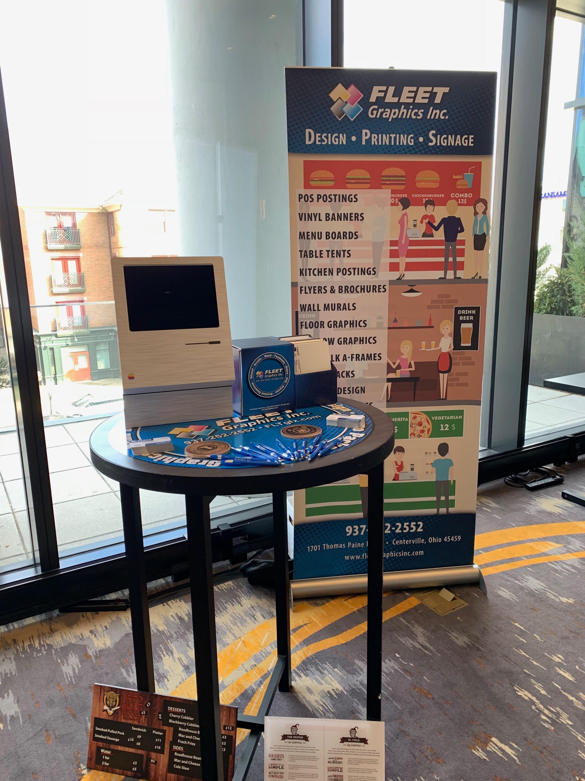 Round table display with a sign for Fleet Freight Inc., a wooden model, and promotional materials.