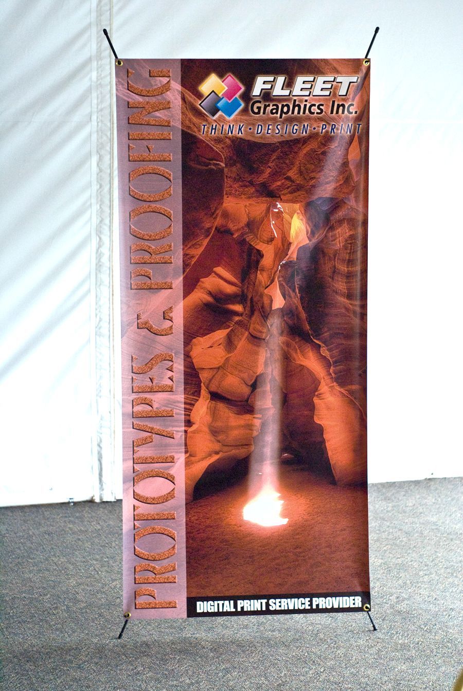 Banner stand for Fleet Graphics Inc. advertising prototypes and proofing. Features a cave image with a light beam.