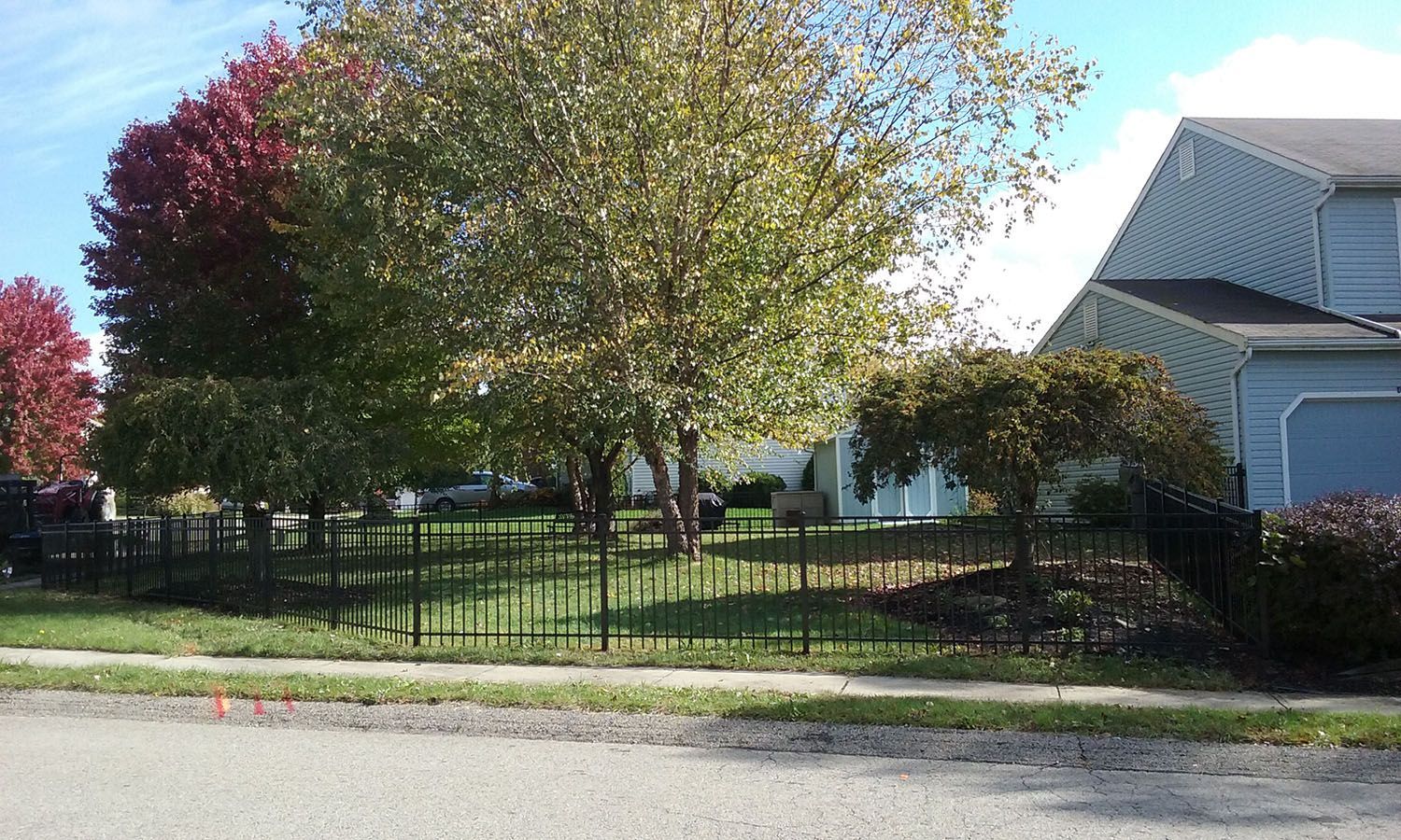 A house with a fence and trees in front of it