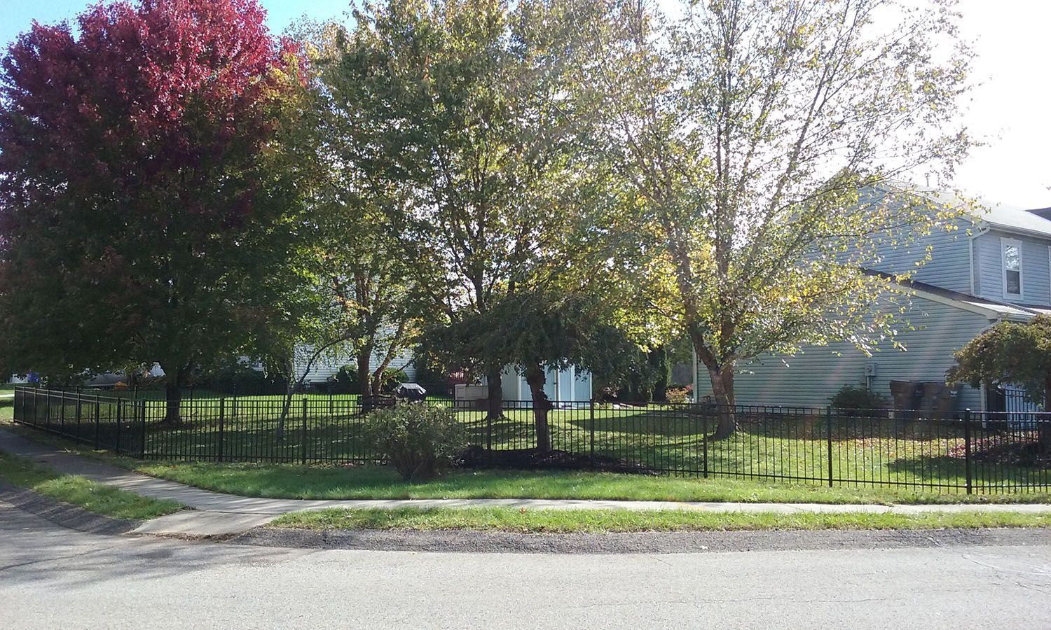 A house with a fence and trees in front of it