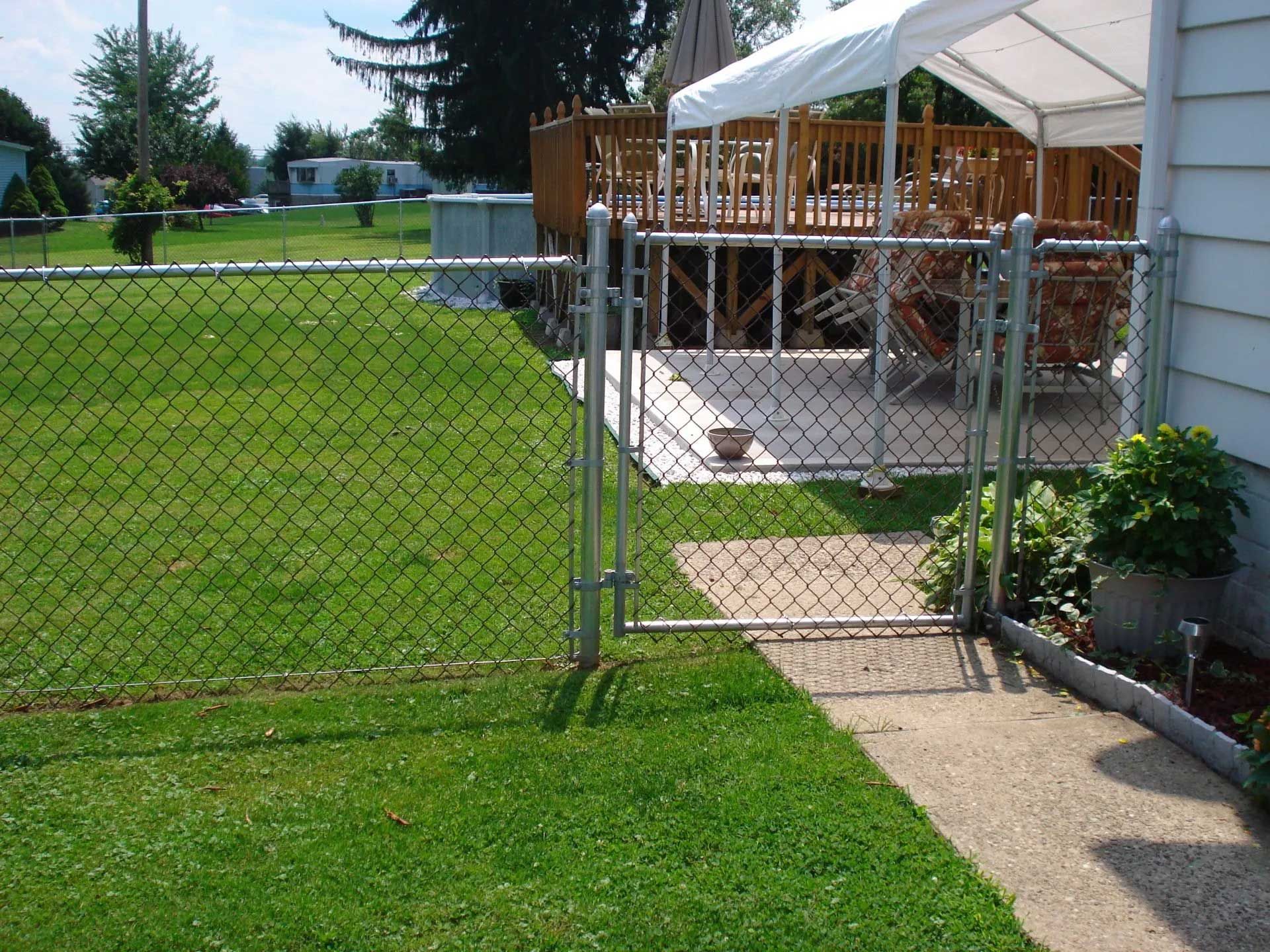 A chain link fence with a gate leading to a deck