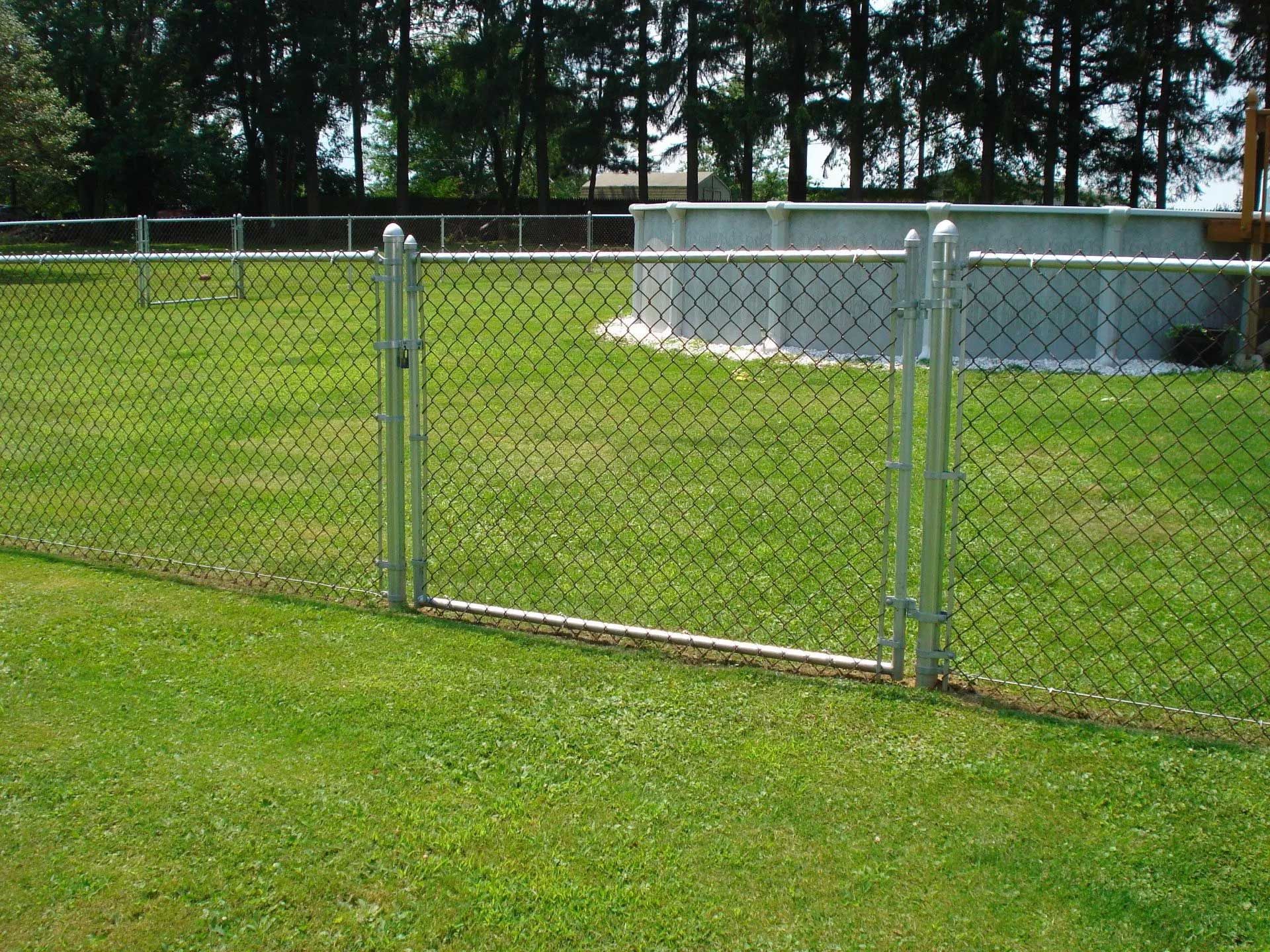A chain link fence surrounds a lush green field