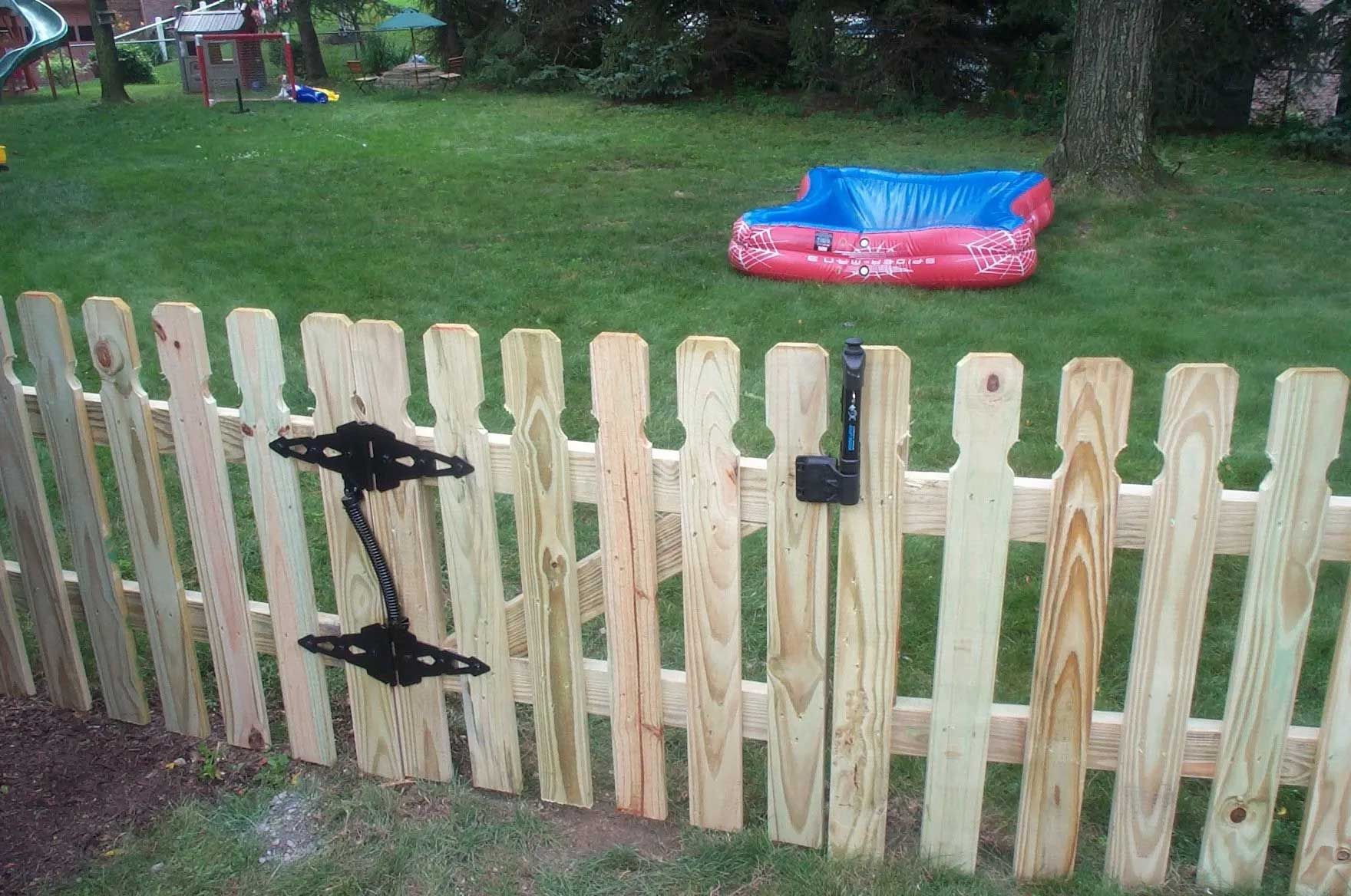 A wooden fence with a pool in the background