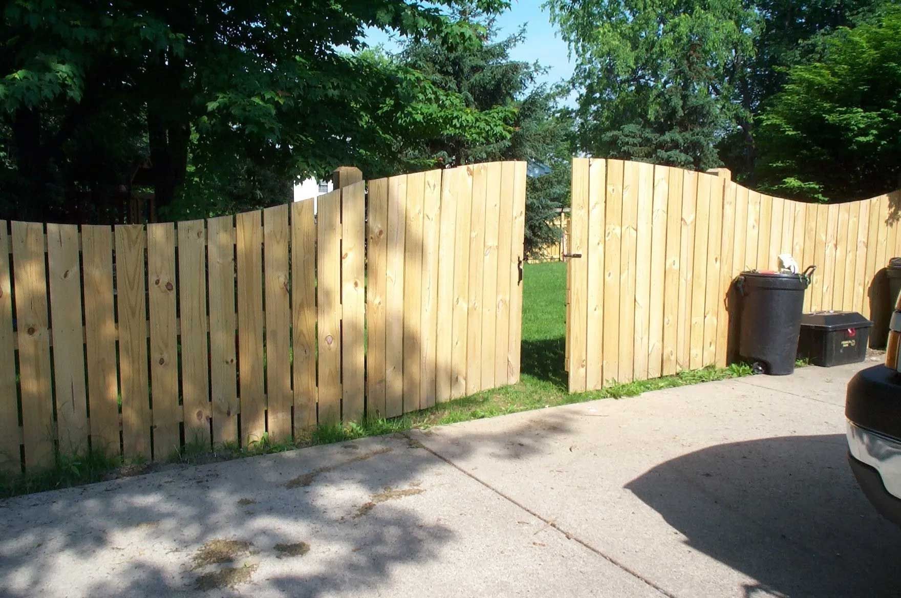 A wooden fence with a gate that is open