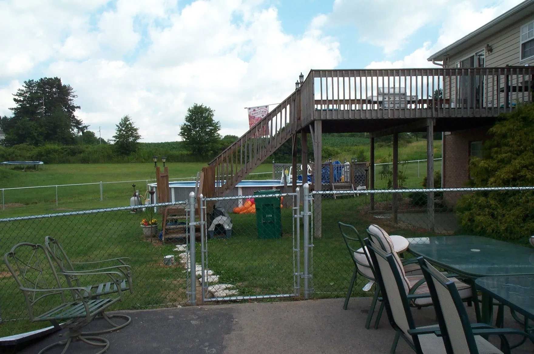 A patio with a table and chairs and a deck