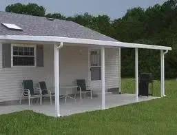White-framed patio cover attached to a house with seating and a grill, set on a concrete slab, and green grass.