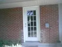 White door with glass panes on a red brick exterior of a building.