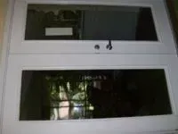 White double door with two rectangular windows, reflecting an interior and exterior view.