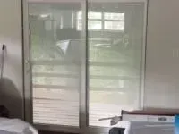 Sliding glass doors with a screen, showing an outdoor view.