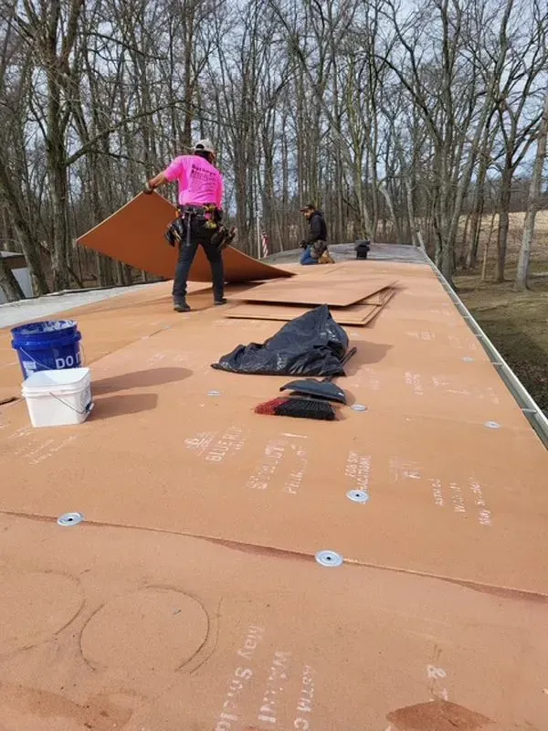 Roofers installing a new flat roof on a sunny day.