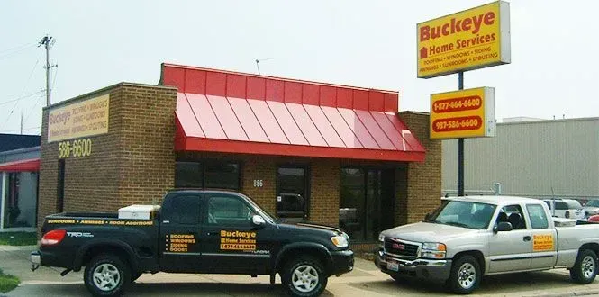 Exterior of Buckeye Auto & Home Services shop with a black Toyota truck and a silver GMC truck parked in front.