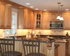 Kitchen with light wood cabinets, granite countertops, and recessed lighting.