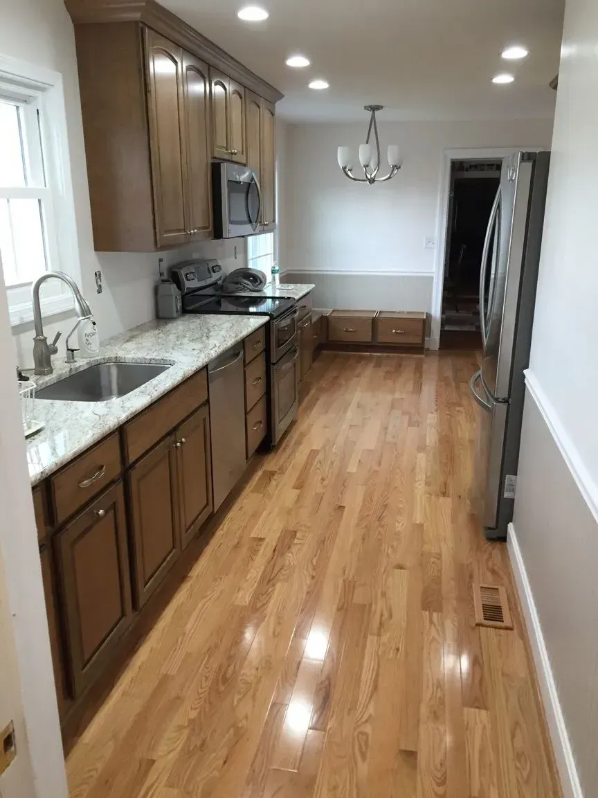 Kitchen with wooden cabinets, granite countertops, and stainless steel appliances. Hardwood floors.