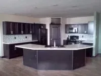 Dark wood kitchen with a large island and white countertops.