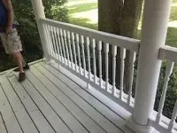 White porch railing and floor, with a person standing nearby.