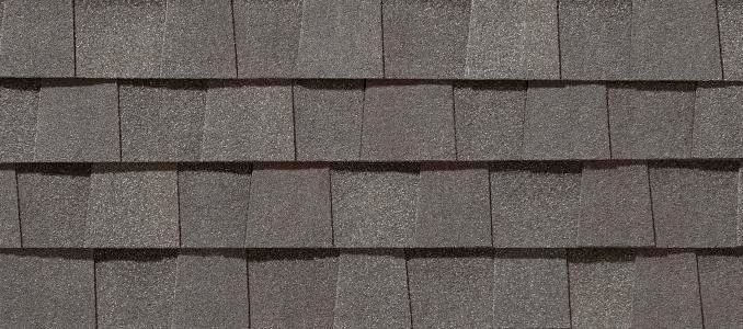 Close-up of gray asphalt roof shingles in an overlapping pattern.