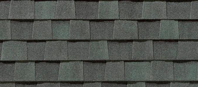 Close-up of a roof covered with dark gray asphalt shingles.