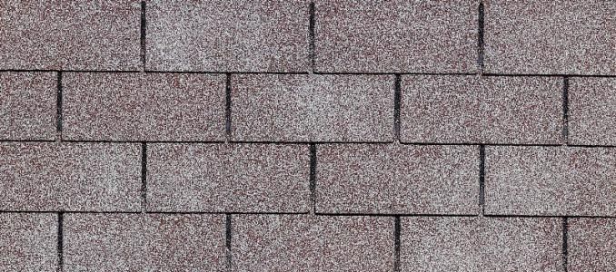Brown asphalt roof shingles in a brickwork pattern.