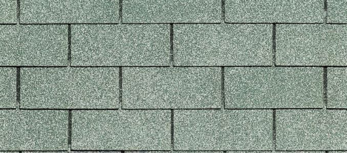 Green asphalt shingles, a building material, in a pattern.