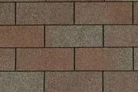 Close-up of brown asphalt roof shingles. Brick-like pattern with varying shades of brown and gray.