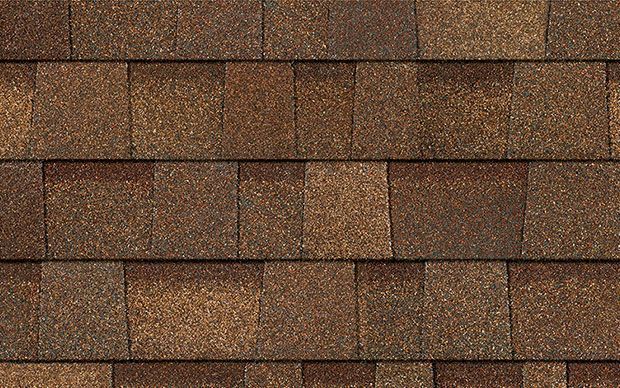 Brown asphalt shingles on a roof, in a repeating pattern.