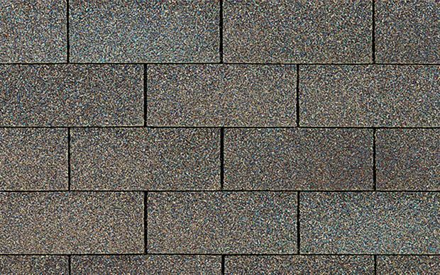 Close-up of asphalt roof shingles in varying shades of brown and gray, arranged in a brick-like pattern.