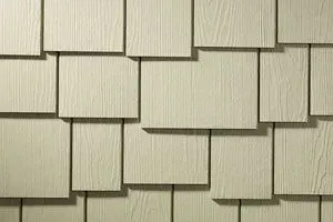 Close-up of tan, square-shaped siding shingles arranged in an overlapping pattern.