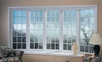 Bay window with white frame and grids, overlooking a misty outdoor scene; a lamp and vase sit on the windowsill.