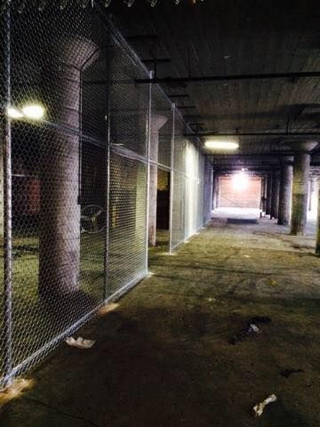 An empty parking garage with a chain link fence surrounding it.