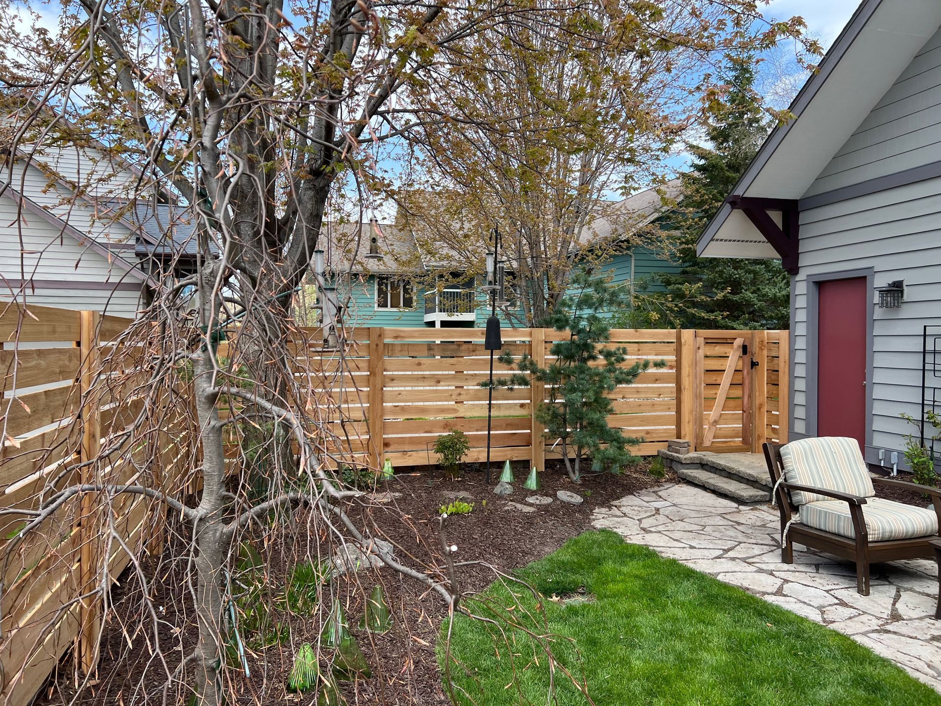 There is a wooden fence in the backyard of a house.