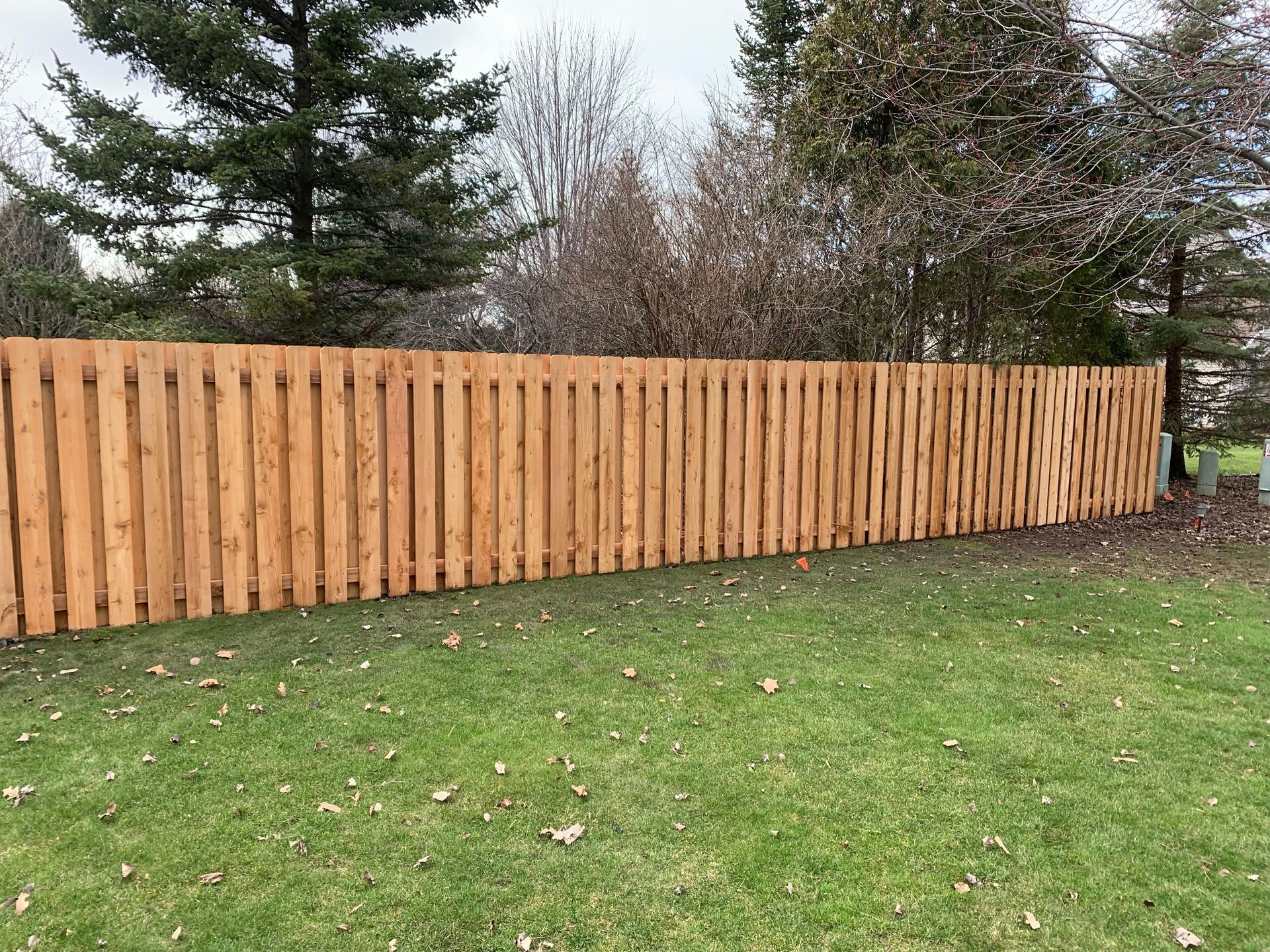 A wooden fence is sitting on top of a lush green lawn.